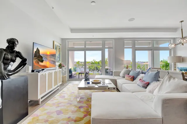 a living room with furniture flat screen tv and a large window