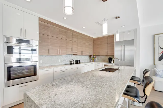 a kitchen with stainless steel appliances granite countertop a sink stove and refrigerator