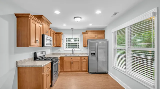 a kitchen that has a sink a stove and cabinets