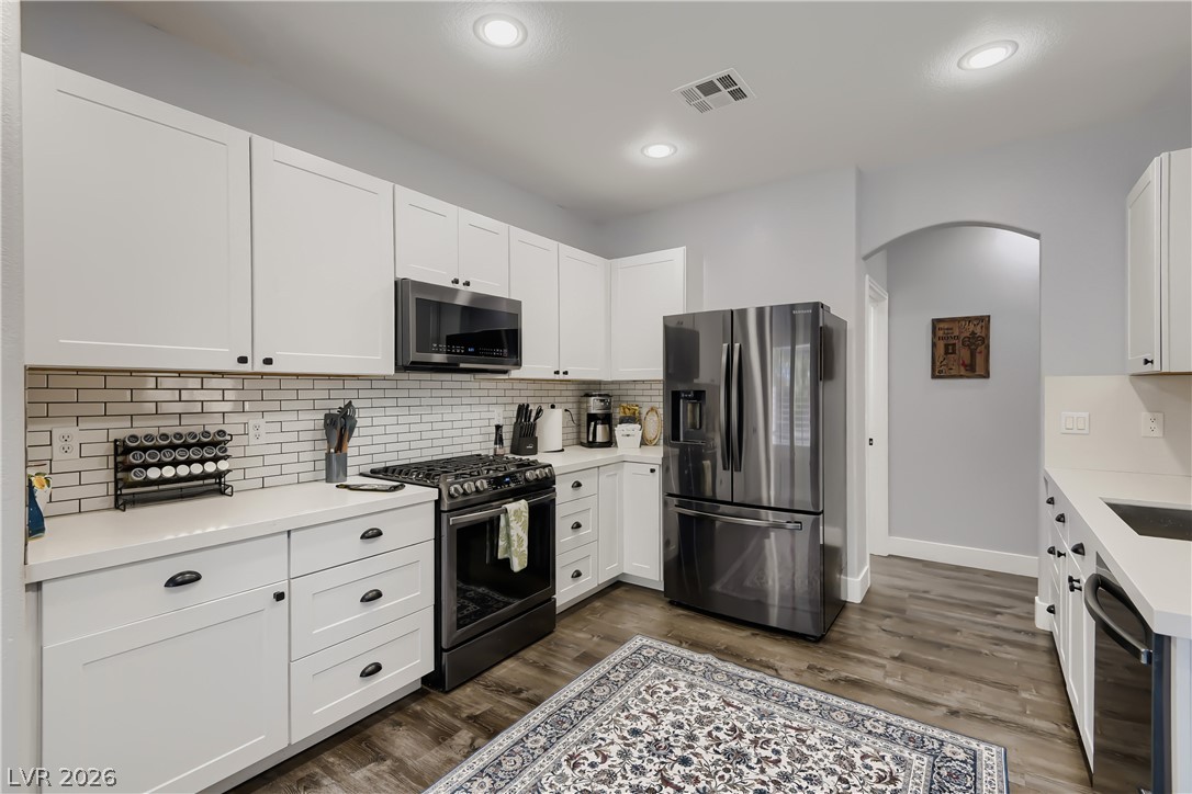 251 Integrity Ridge Drive Henderson, NV 89052 - Photo 9 of 28 A contemporary kitchen showcasing sleek stainless steel appliances and white cabinetry.