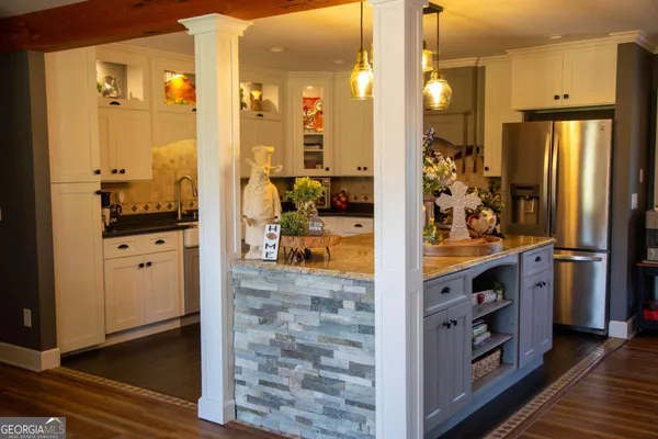 a kitchen with stainless steel appliances kitchen island granite countertop a refrigerator a stove and a sink