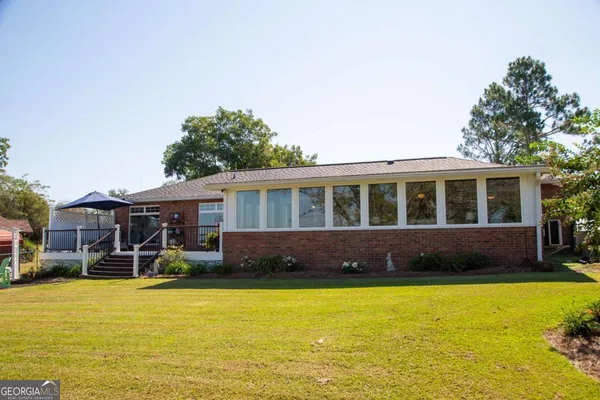 a view of a house with backyard and sitting area