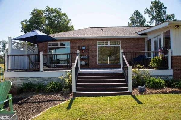 a patio with tables and chairs under an umbrella