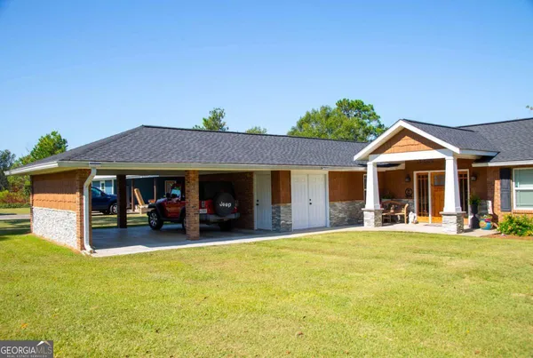 a view of a house with a yard and sitting area