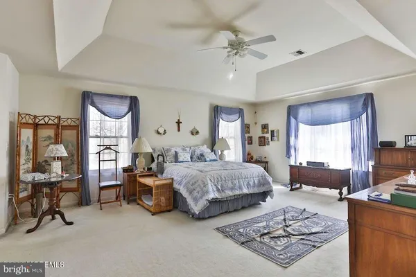 a spacious bedroom with a bed a table and chair