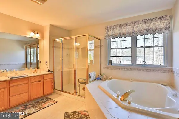 a bathroom with a tub a sink and a large mirror