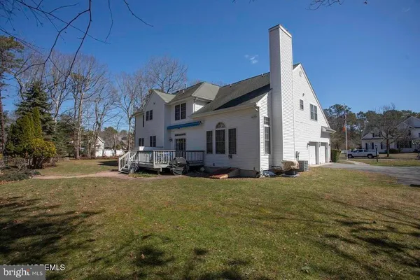 a view of a house with a big yard and large trees