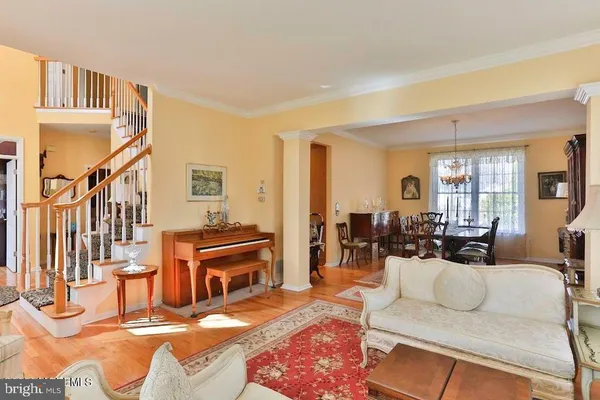 a living room with furniture kitchen view and a large window
