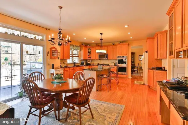 a dining room with furniture a chandelier and wooden floor