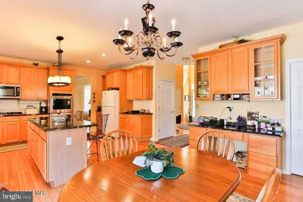 a view of a dining room with furniture a chandelier and large windows
