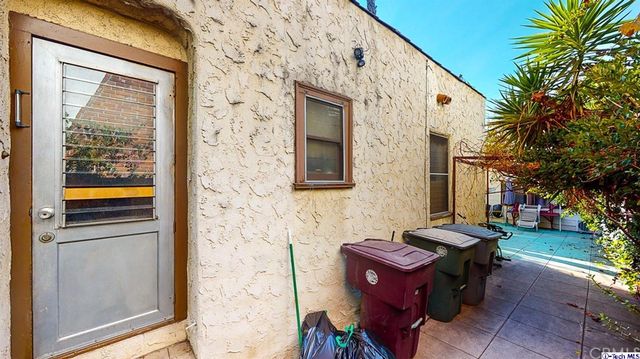 a view of a patio with table and chairs potted plants and a large tree