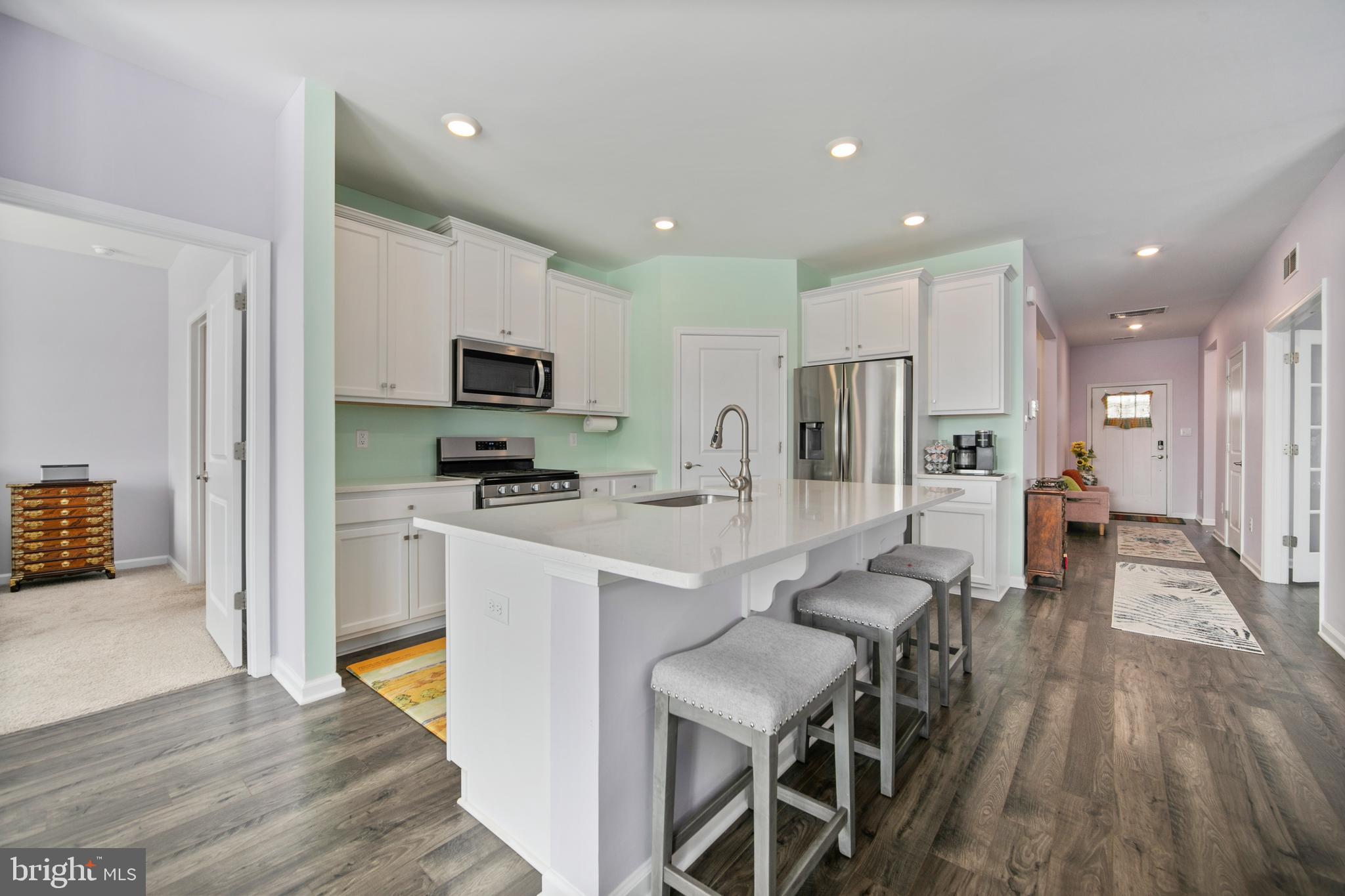 33 Walton Way Delanco, NJ 08075 - Photo 13 of 46 a kitchen with stainless steel appliances granite countertop a stove top oven a sink dishwasher a refrigerator and a dining table with wooden floor