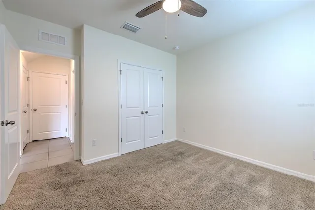 an empty room with a ceiling fan and a window