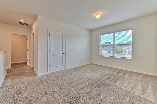 an empty room with windows and closet