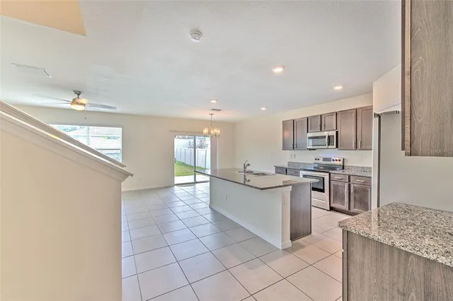 a kitchen with stainless steel appliances kitchen island granite countertop a refrigerator and a sink