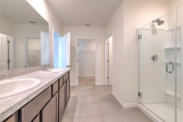 a spacious bathroom with a granite countertop sink a mirror and a shower