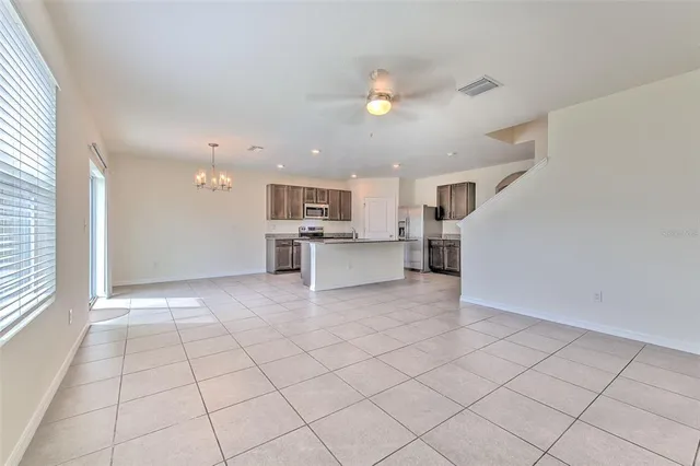 a view of a electric appliances in kitchen and empty room with wooden floor
