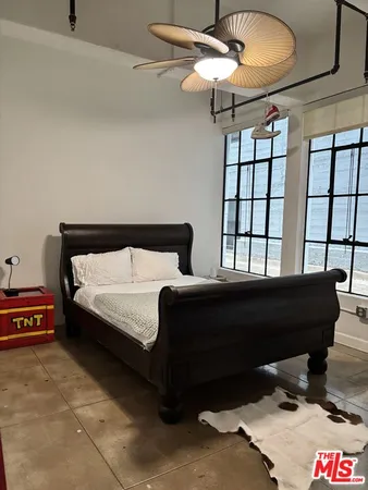 a bedroom with a bed a dresser and a chandelier