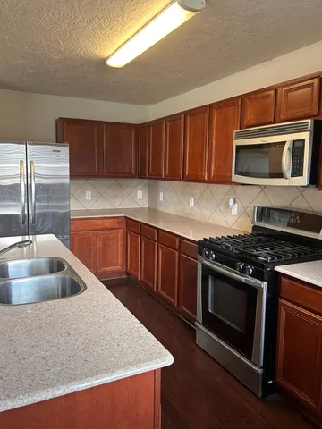 a kitchen with granite countertop a sink and a stove top oven