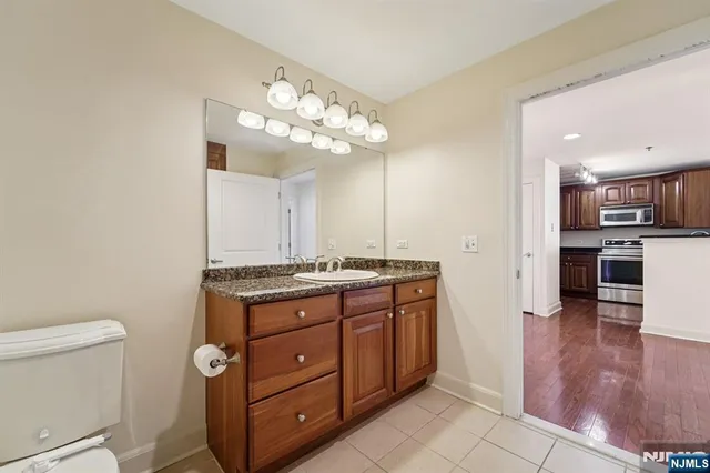 a view of a kitchen with a sink and dishwasher a stove top oven with wooden floor