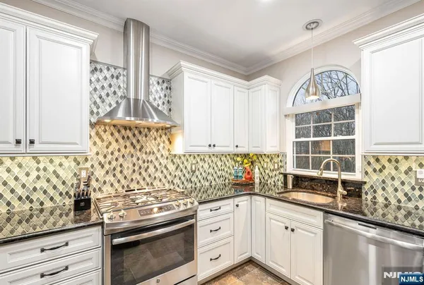 a kitchen with granite countertop white cabinets and window