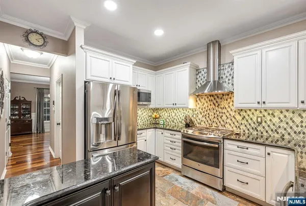 a kitchen with granite countertop cabinets stainless steel appliances and a counter space