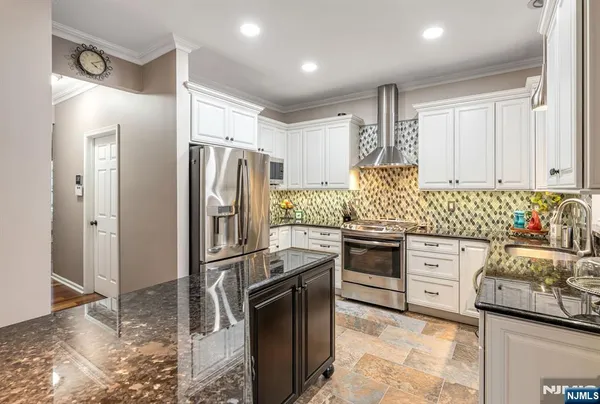 a kitchen with stainless steel appliances granite countertop a refrigerator stove and sink
