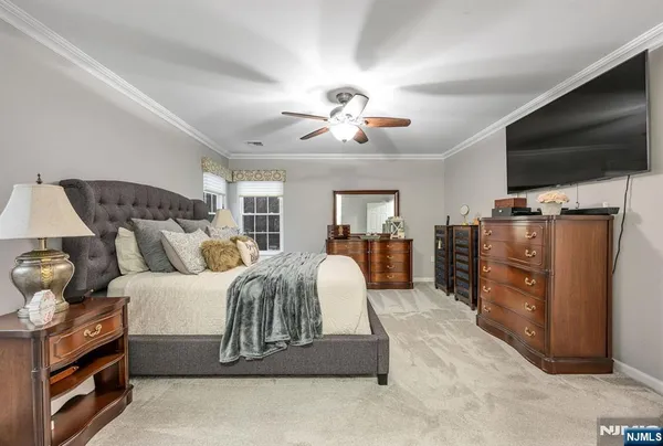 a spacious bedroom with a bed and flat screen tv