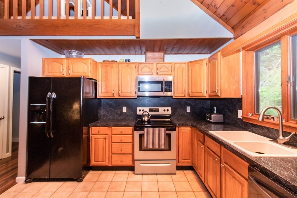 34 Union Road Holland, MA 01521 - Photo 8 of 29 a kitchen with stainless steel appliances granite countertop a sink a stove and a refrigerator