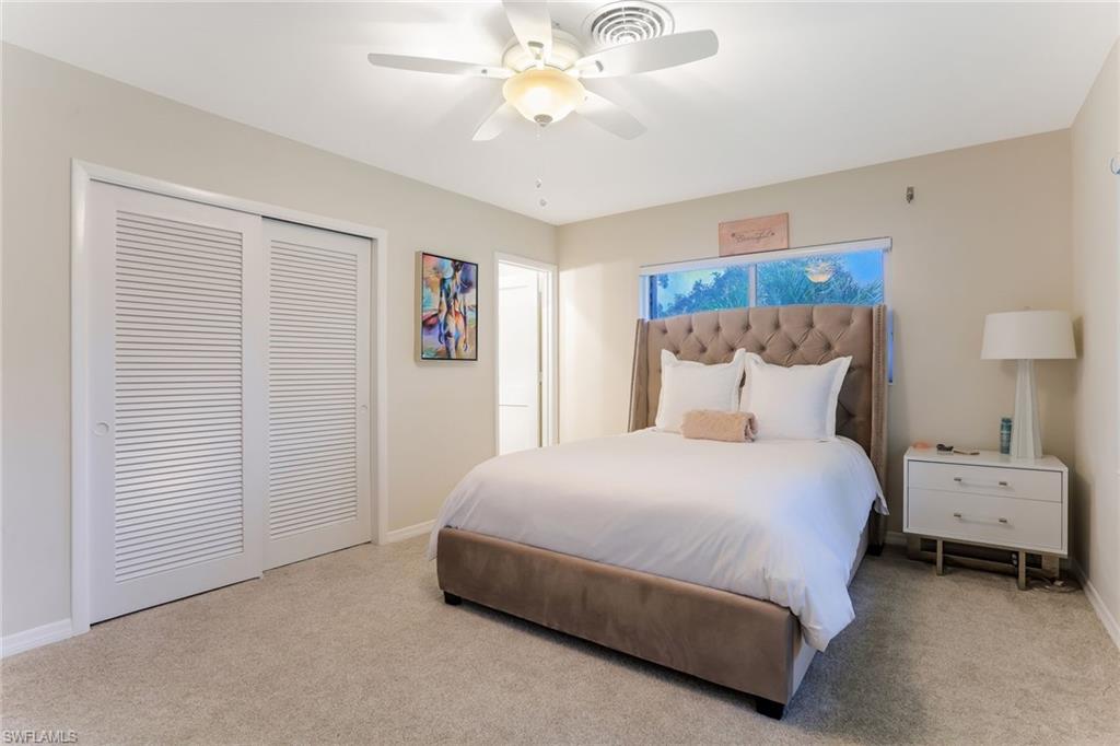 1340 Crayton Road, Unit 4 Naples, FL 34102 - Photo 11 of 20 a bedroom with a bed and a chandelier