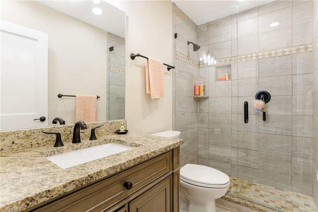 1340 Crayton Road, Unit 4 Naples, FL 34102 - Photo 14 of 20 a bathroom with a granite countertop sink a toilet and a shower