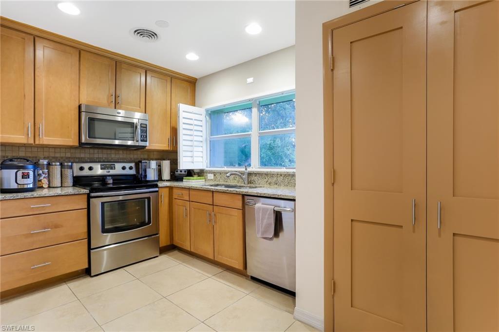 1340 Crayton Road, Unit 4 Naples, FL 34102 - Photo 8 of 20 a kitchen with stainless steel appliances granite countertop a stove and a microwave