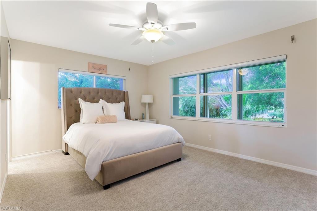 1340 Crayton Road, Unit 4 Naples, FL 34102 - Photo 10 of 20 a bedroom with a large bed and a chandelier