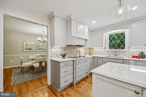 a kitchen that has a lot of cabinets in it and wooden floors
