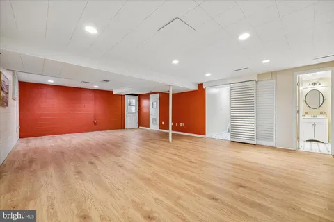 a view of an empty room with wooden floor and windows