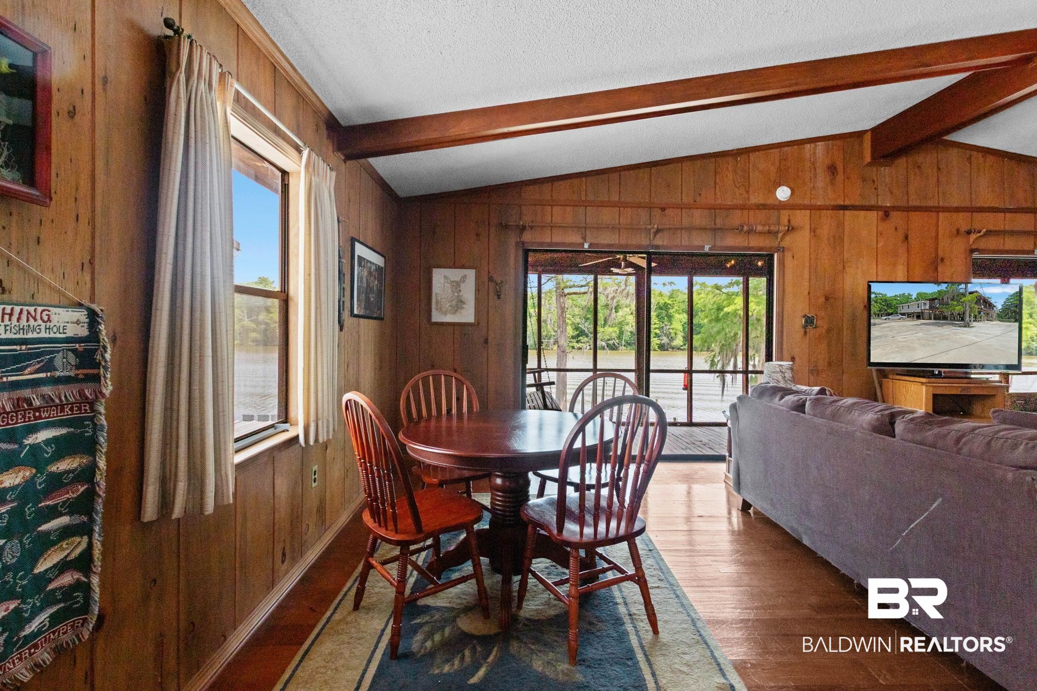 8153 Bryant's Lndg Road Stockton, AL 36579 - Photo 34 of 87 Living area featuring wood paneling throughout, an exposed beam ceiling, wood-finish flooring, and a large window