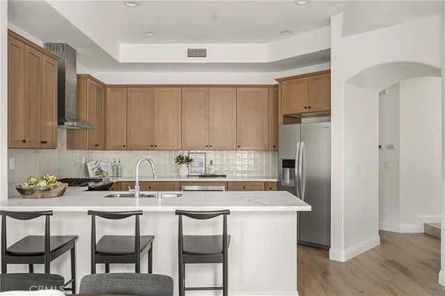 a kitchen with stainless steel appliances granite countertop a table chairs stove refrigerator and cabinets