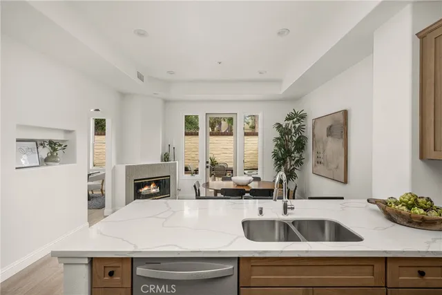 a kitchen with a sink and a stove with wooden floor