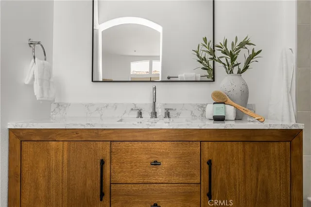 a bathroom with a granite countertop sink and a mirror