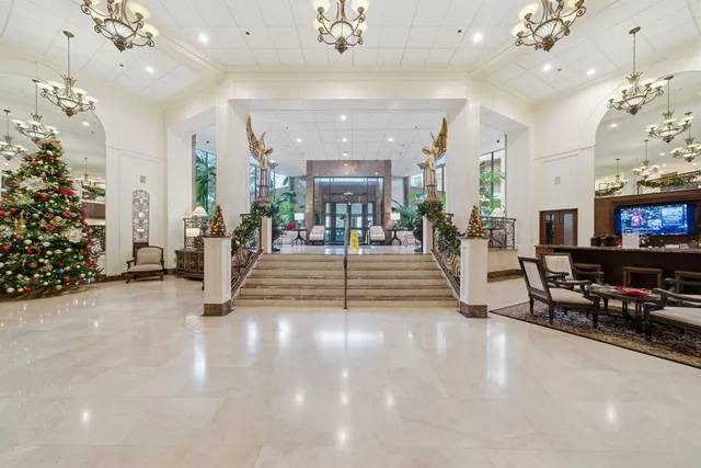 an entryway in a hall with a chandelier and a fireplace