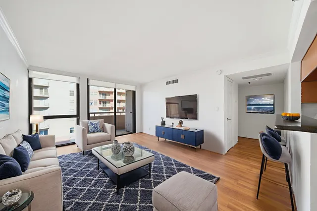 a living room with furniture a flat screen tv and a large window