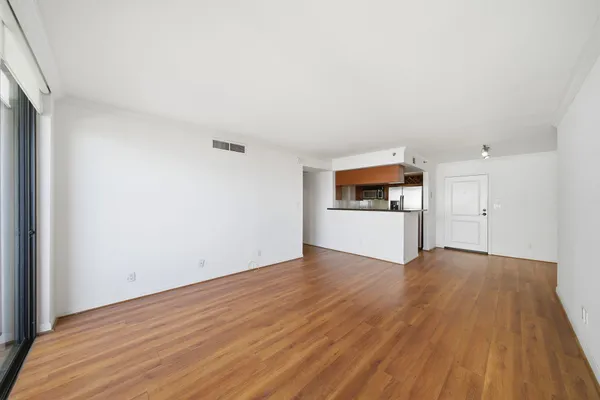 a view of a big room with wooden floor and windows