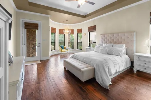 a spacious bedroom with a bed and a large window with wooden floor