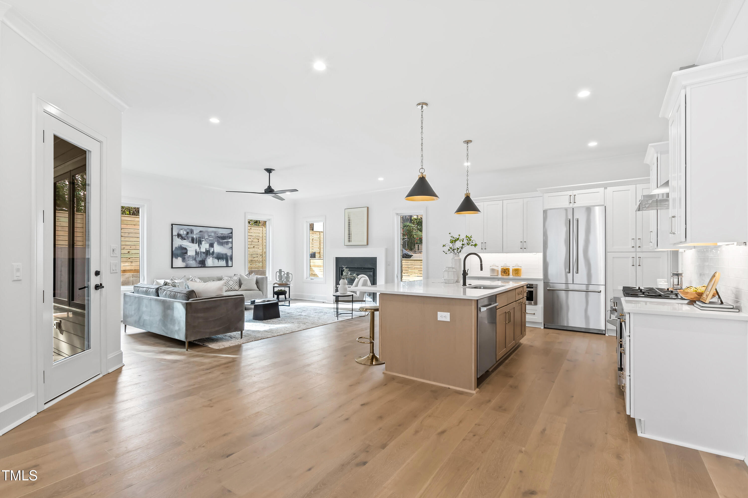 2417 Mayview Road Raleigh, NC 27607 - Photo 10 of 61 a kitchen with kitchen island wooden floors stainless steel appliances and living room view