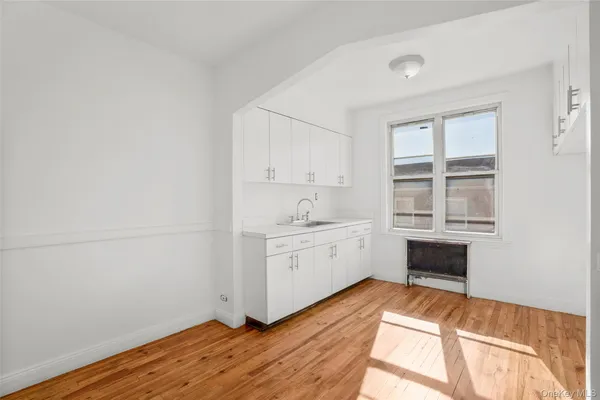 a view of a kitchen with wooden floor and a sink