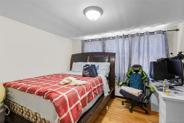 a bedroom with a bed table and a flat screen tv