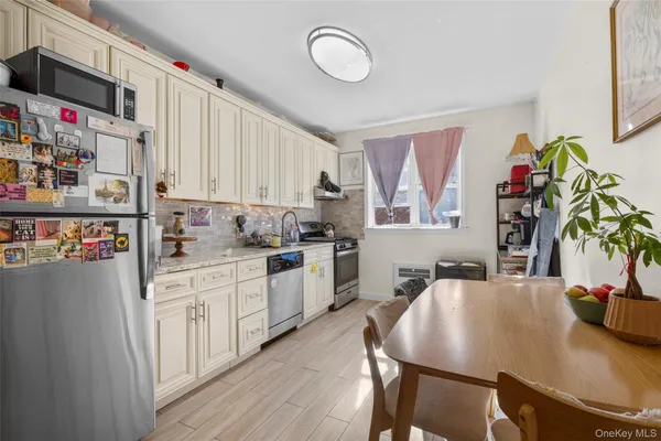 a kitchen with granite countertop a sink appliances cabinets and living room view