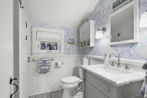 a bathroom with a granite countertop toilet sink and mirror