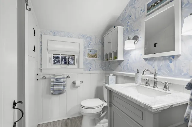 a bathroom with a granite countertop toilet sink and mirror
