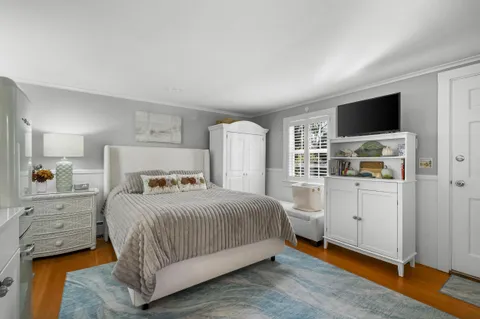 a bedroom with a bed and a flat screen tv